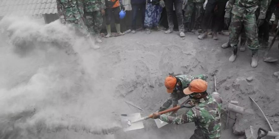 Soldaten suchen nach Opfern, nachdem ein Haus unter der Vulkanasche verschüttet wurde. Drei Tage nach dem Vulkanausbruch auf der indonesischen Insel Java ist die Zahl der Toten weiter gestiegen. Foto: Trisnadi/AP/dpa