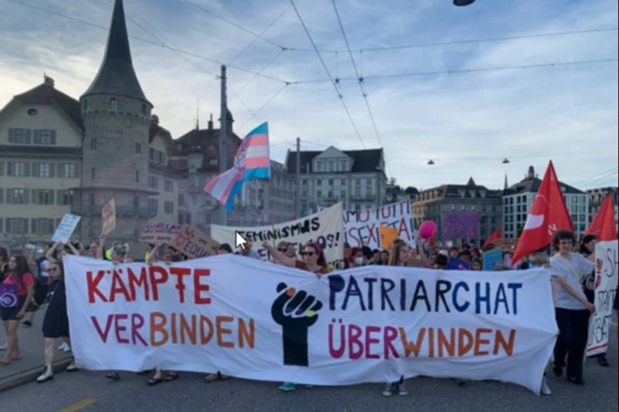 Streikende tragen beim Umzug in Luzern ein Tuch mit der Aufschrift «Kämpfe verbinden – Patriarchat überwinden».