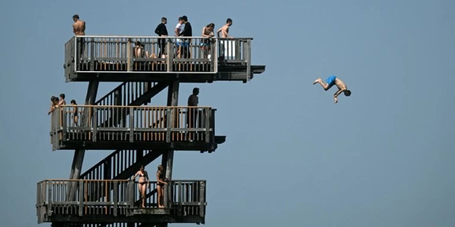 Junge Leute auf einem Sprungturm am bayerischen Ammersee