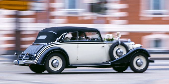 Wer sich für den «schönsten Tag im Leben» ein ebenso schönes Auto ausleihen will, sollte auch bei Freundschaftsdiensten einiges beachten. Auto schwarz weiss Oldtimer Hochzeit Blumenschmuck