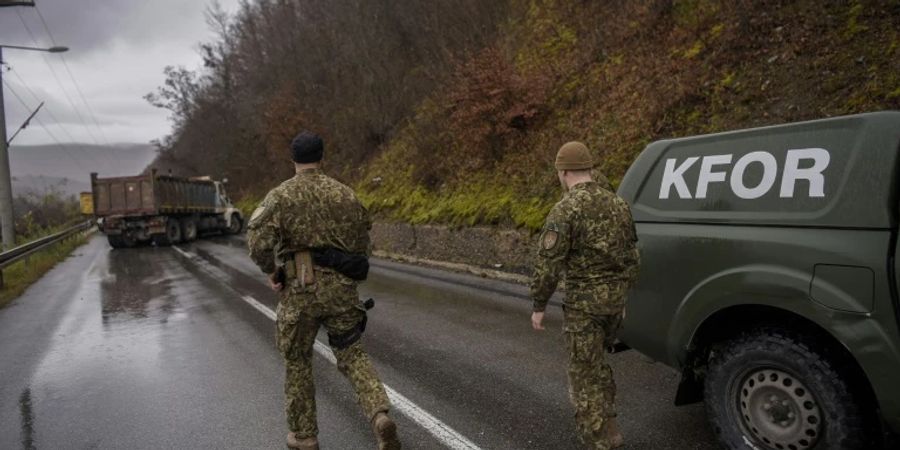 Soldaten der Nato-Mission Kfor inspizieren eine der blockierte Strassen