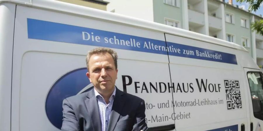 Pfandleiher und Gebrauchtwagenhändler Bernd Wolf hat sich auf das Beleihen von Autos und Motorrädern spezialisiert. Foto: Sebastian Kramer/dpa