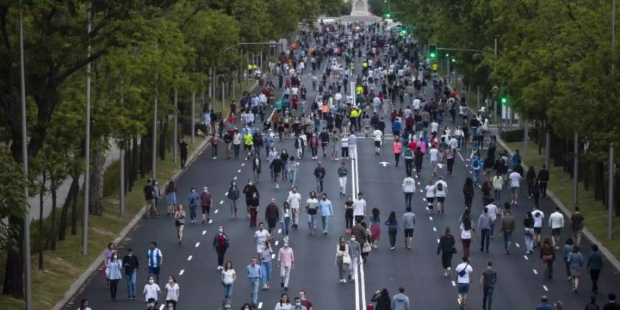 Menschen treiben auf dem Paseo de la Castellana in Madrid Sport. Die spanische Hauptstadt ist vor Barcelona die von der Pandemie am schwersten getroffene Region des Landes. Foto: Manu Fernandez/AP/dpa