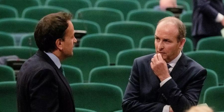 Fianna Fail leader Micheal Martin (R) talks with the man who he has replaced as Irish prime minister, Leo Varadkar after the vote at a special sitting of the Dail parliament
