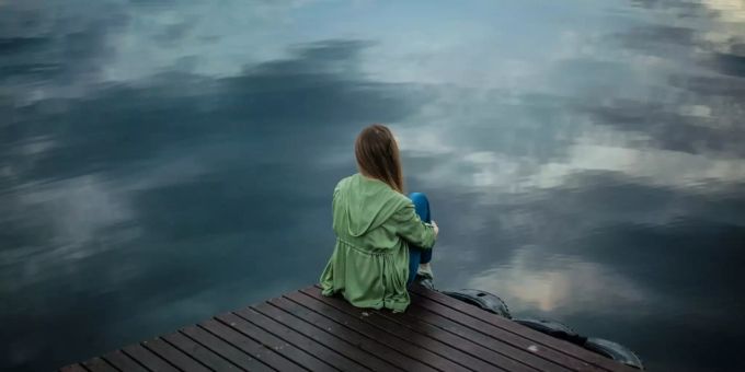 Nach einer Trennung fühlt man sich oft einsam. (Symbolbild) Frau alleine am See