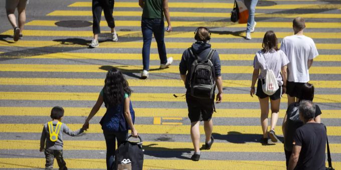 Fussgänger überqueren einen Zebrastreifen.