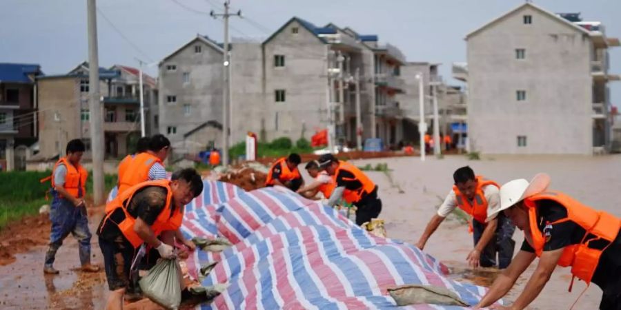 Rettungshelfer errichten einen provisorischen Deich gegen Überschwemmungen in einem Gebiet im Kreis Poyang in der ostchinesischen Provinz Jiangxi. Foto: Zhang Haobo/Xinhua/dpa