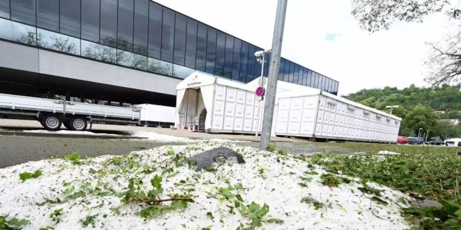 Am Tag nach einem Unwetter liegen noch Hagelkörner vor dem Impfzentrum in Tübingen. Foto: Bernd Weissbrod/dpa