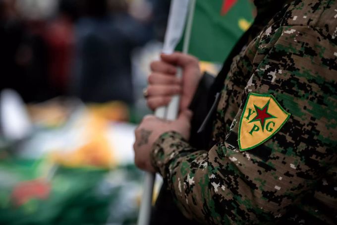 Ein Demonstrant trägt eine Jacke mit dem YPG-Logo. Kurden-Proteste in Köln