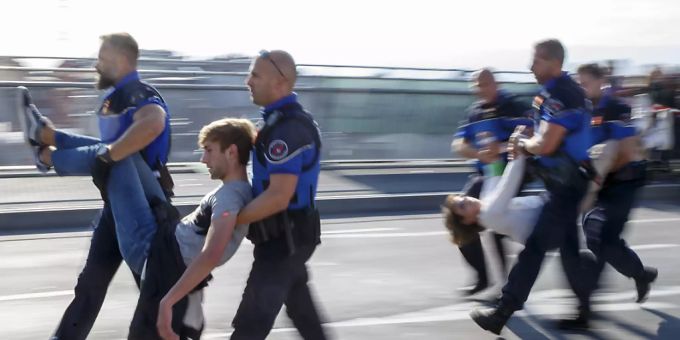 Aktivisten der Bewegung «Extinction Rebellion» werden von der Polizei weggetragen und in Gewahrsam genommen, nachdem sie eine zentrale Brücke in Lausanne blockiert hatten. (Archivbild). xr