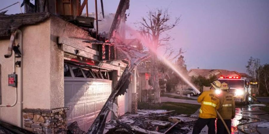 Feuerwehrleute löschen ein brennendes Haus im südkalifornischen Santa Clarita. Foto: David Crane/Orange County Register via ZUMA/dpa