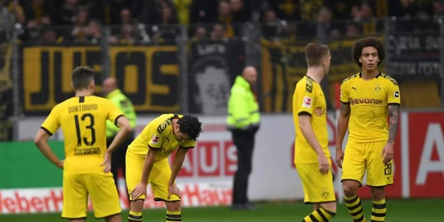 Sind sich selbst ein Rätsel: Die BVB-Spieler stehen nach dem Remis beim SC Freiburg mit hängenden Köpfen auf dem Spielfeld. Foto: Patrick Seeger/dpa