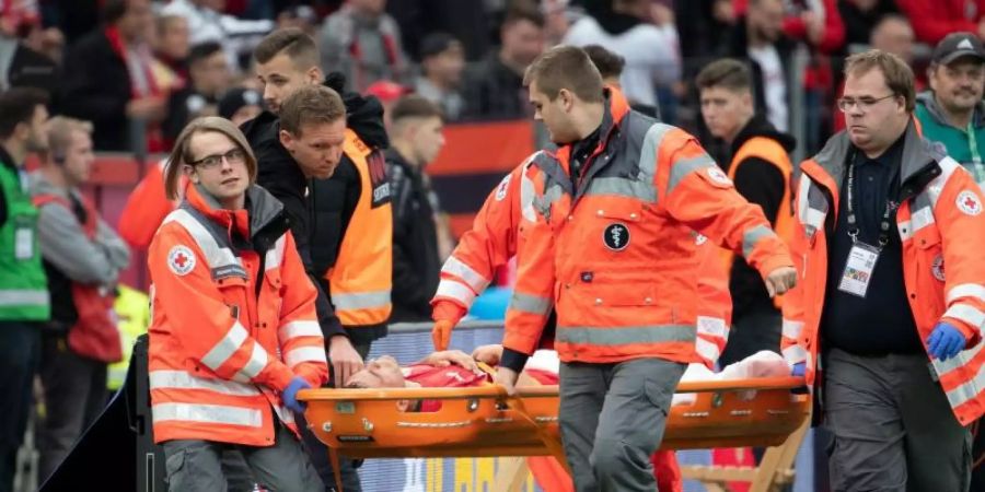 Leverkusens Charles Aranguiz wird verletzt vom Platz getragen. Foto: Federico Gambarini/dpa