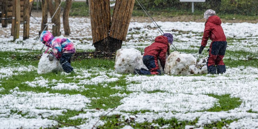 Kinder in Straubing versuchen, einen Schneemann zu bauen.