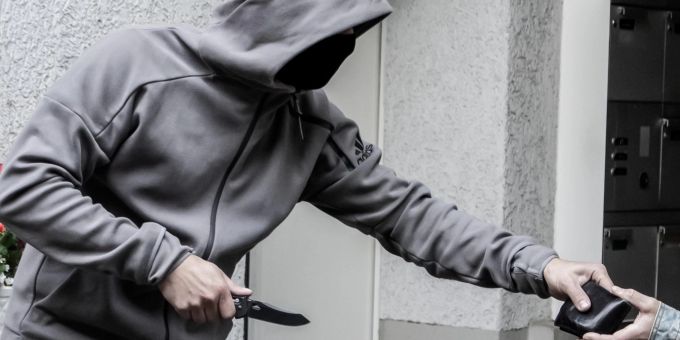 Ein Mann mit einem Messer begeht einen Raubüberfall (Smbolbild) Raubüberfall optikergeschäft