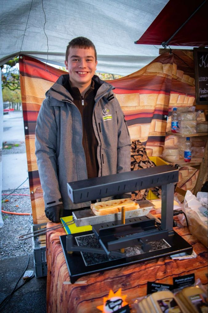 Mauro Spiess aus Beromünster, Luzern, macht Raclette-Brote zum degustieren.