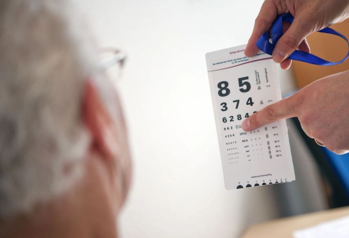 Sichergehen, dass die Brillenglasstärke noch passt: Wer regelmässig einen Sehtest macht, kann Stürzen vorbeugen. Sehtest Mann Ziffern Hand