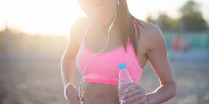 Frau mit Sport-BH und Wasserflasche