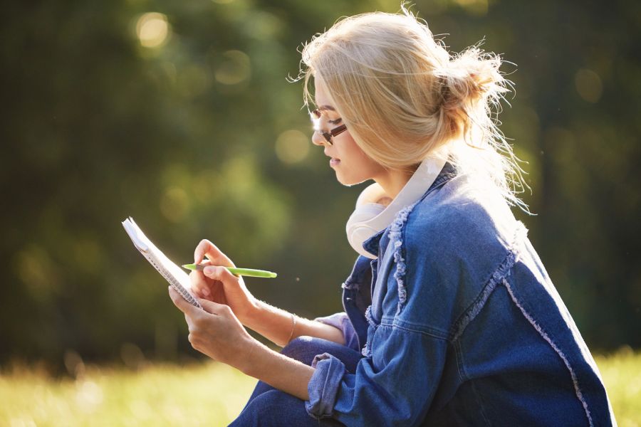 Frau mit Notizbuch in der Natur