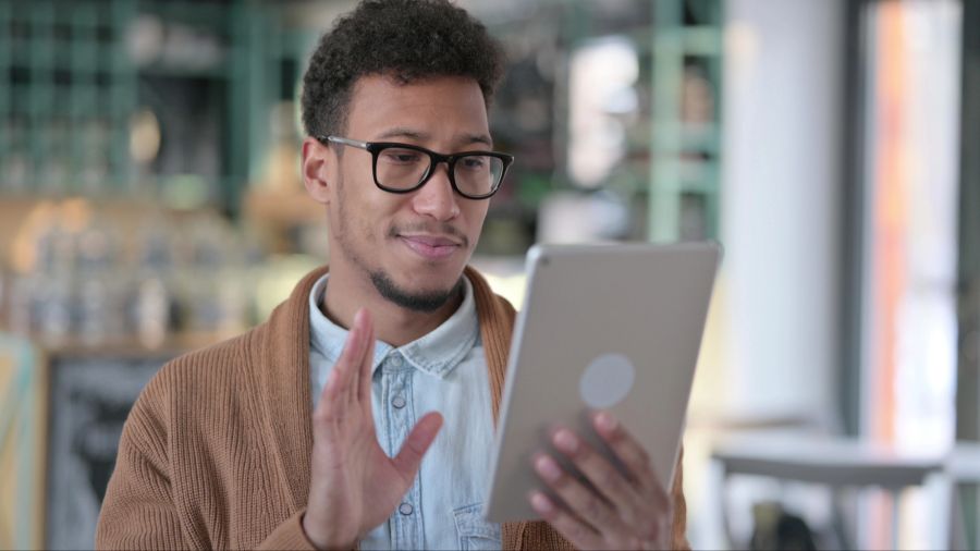 Mann winkt ins Tablet