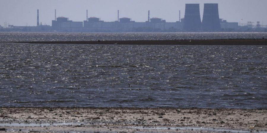ARCHIV - Das von russischen Truppen besetzte Kernkraftwerk Saporischschja ist im Hintergrund des flachen Kachowka-Stausees nach der Zerstörung des Staudamms zu sehen. Foto: Kateryna Kl...