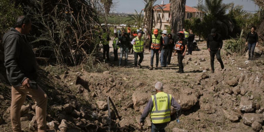 Anwohner und israelische Sicherheitskräfte inspizieren den Einschlagsort einer iranischen Rakete in Zentralisrael. Foto: Leo Correa/AP/dpa