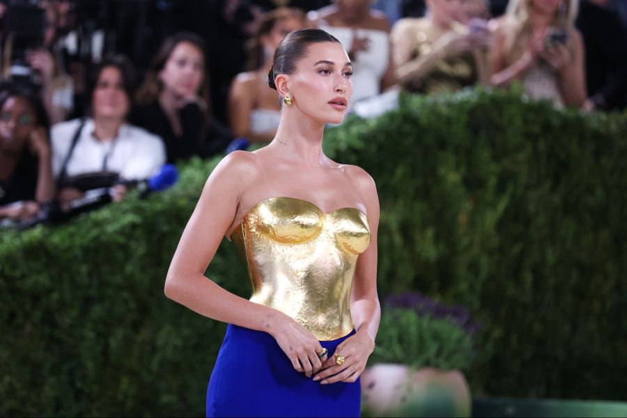 Hailey Bieber erschien in einem skulpturalen Gold-Look von Saint Laurent.