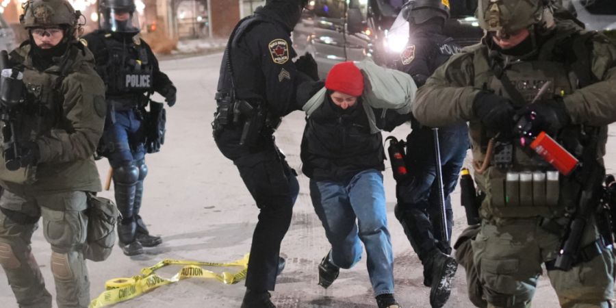 dpatopbilder - Polizeibeamte halten einen Demonstranten während einer Protestaktion vor den Hotels SpringHill Suites und Residence Inn by Marriott in Maple Grove, Minnesota, fest. Foto...