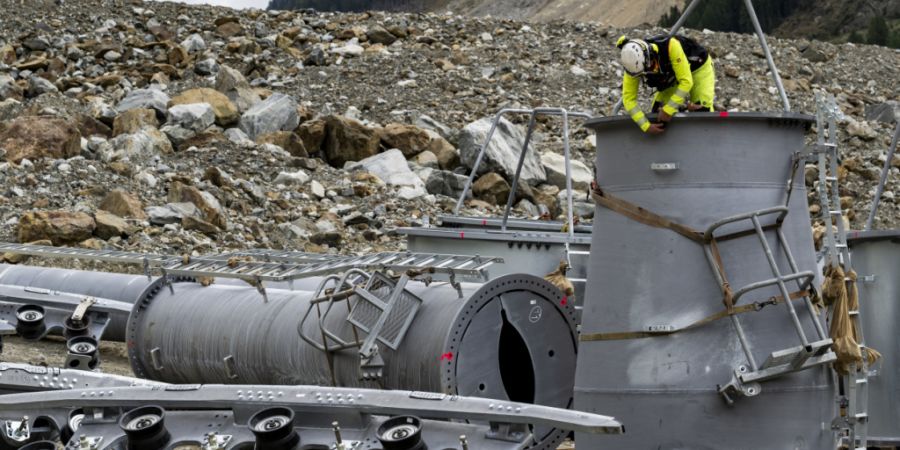Ein Arbeiter befestigt das Seil an den Masten der neuen Seilbahn, die das Dorf Wiler mit dem Weiler Weissenried im Lötschental verbinden soll.