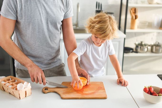 Kinder sollten dem Umgang mit Lebensmitteln und deren Zubereitung früh spielerisch lernen. Vater Kind Küche
