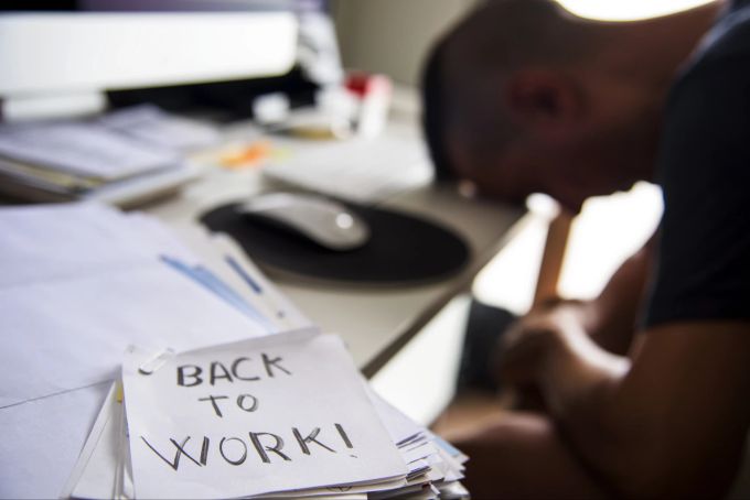 Arbeit, Stress, Alltag ‒ trotz erholsamer Ferien ist die Rückkehr zur Normalität nicht immer leicht. Back to work, Mann, verzweifelt, Symbolbild