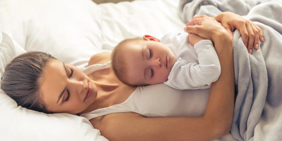 Mutter schläft mit Baby auf dem bauch