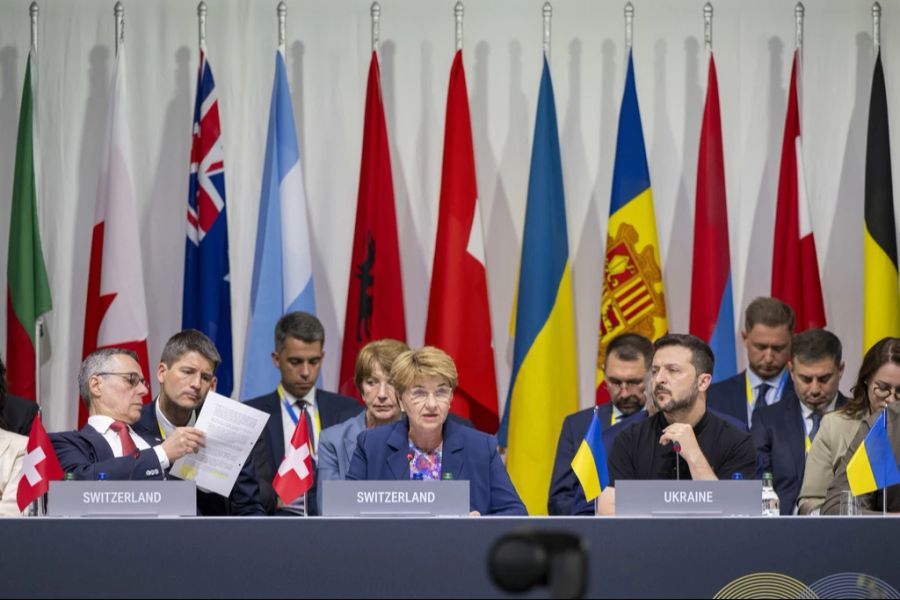 Das Podium während der Bürgenstock-Konferenz, mit Aussenminister Ignazio Cassis (links), Bundespräsidentin Viola Amherd (Mitte) und Ukraine-Präsident Wolodymyr Selenskyj (rechts), sowie Brigitte Hauser-Süess unmittelbar hinter Amherd.