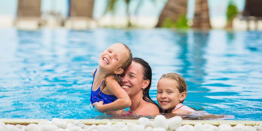 Frau mit Kindern im Pool