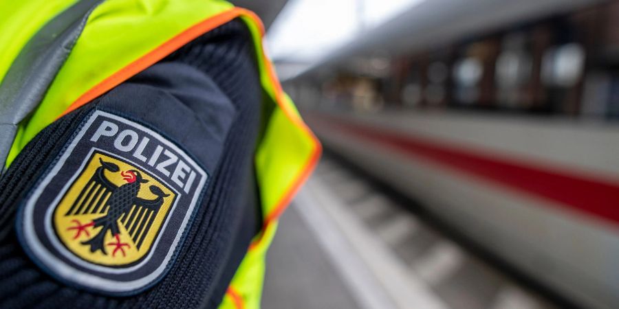 Ein Bundespolizist an einem Hauptbahnhof vor einem ICE.