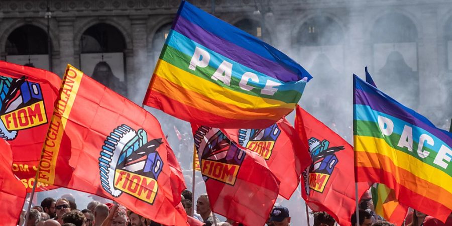 Demonstranten schwenken Fahnen während der Demonstration «Italien, Europa, hört auf die Arbeitswelt», die ein Jahr nach dem Angriff einer Gruppe von rechtsextremen Aktivisten auf den Sitz der Gewerkschaft «Confederazione Generale Italiana del Lavoro» (CGIL) stattfindet. Die Demonstranten fordern die italienische und die europäische Regierung auf, soziale Gerechtigkeit und die Probleme der Arbeitswelt wieder in den Mittelpunkt der politische Debatten zu stellen. Foto: Mauro Scrobogna/LaPresse/AP/dpa