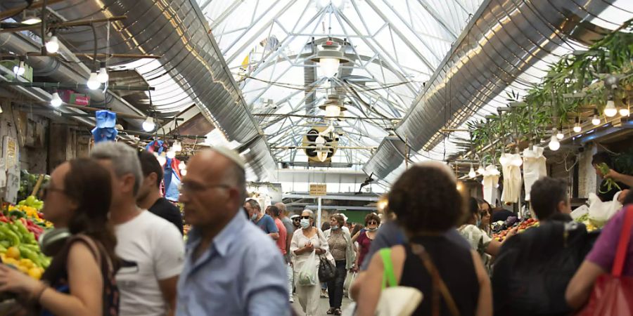 ARCHIV - Menschen tragen Schutzmasken, während sie auf dem Mahane Yehuda Markt einkaufen. Foto: Maya Alleruzzo/AP/dpa