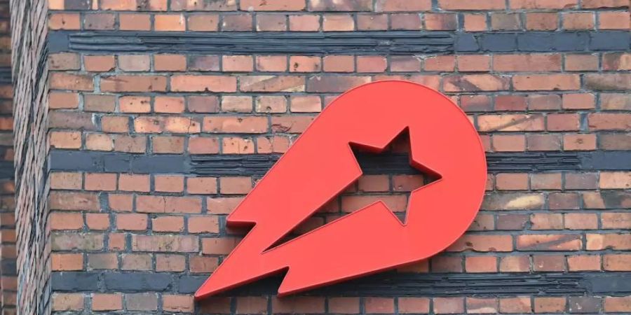 Das Logo Essenslieferdienstes Delivery Hero ist an einer Wand der Zentralein Berlin angebracht. Foto: Britta Pedersen/dpa-Zentralbild/dpa