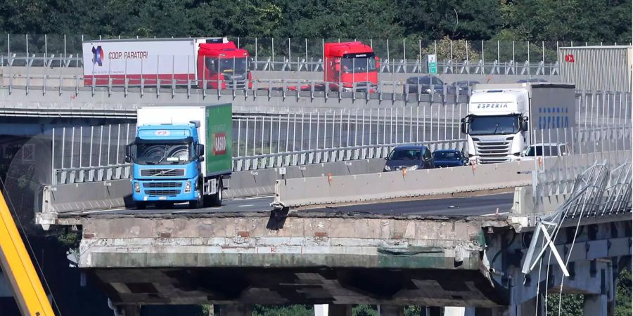 Der grün-blaue Lastwagen steht nur wenige Meter vor dem Abgrund der eingestürzten Morandi-Brücke in Genua (I).