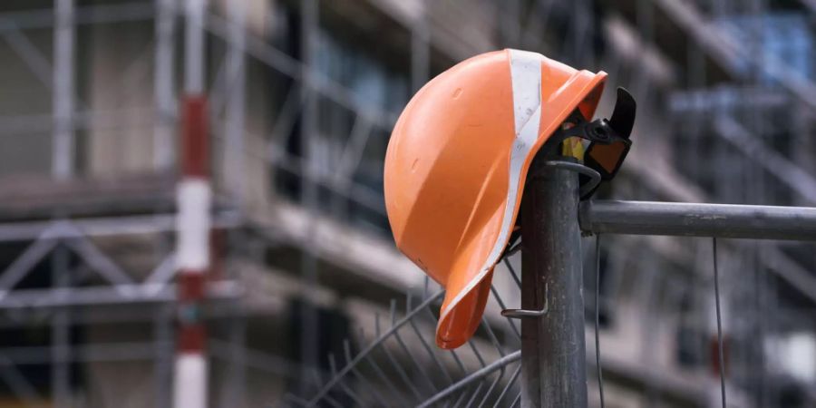 Oranger Helm auf Baustellenabsperrung - Keystone
