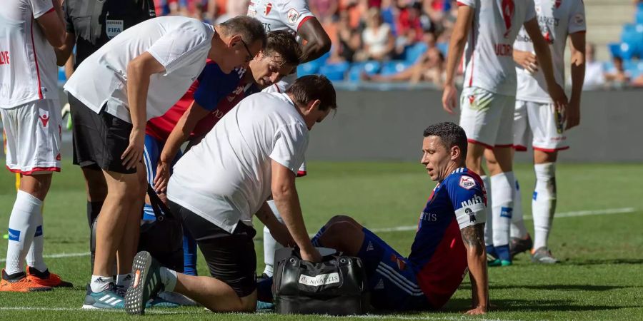 Basels Marek Suchy, (mitte) sitzt verletzt am Boden. Der Abwehrchef hat sich im Meisterschaftsspiel gegen Sion im Stadion St. Jakob-Park verletzt.