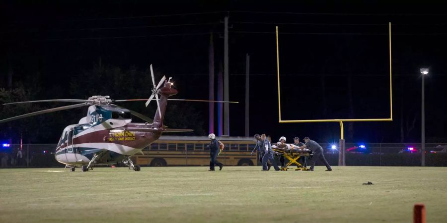 Nachdem bei einem Footballspiel an der Palm Beach Central High School Schüsse gefallen sind, transportieren Sanitäter eine verletzte Person zu einem Hubschrauber.