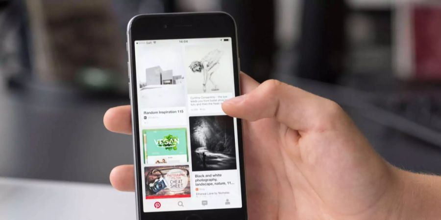 Ein Handynutzer hat die App des Foto-Sharing-Anbieters Pintrest geöffnet.