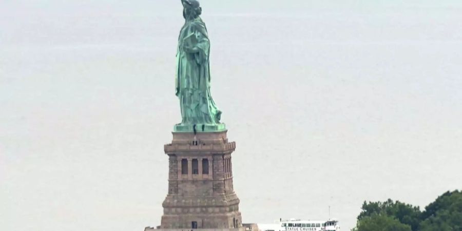 Protestaktion gegen die Immigrationspolitik von Donald Trump: Eine Frau klettert auf den Sockel der Freiheitsstatue