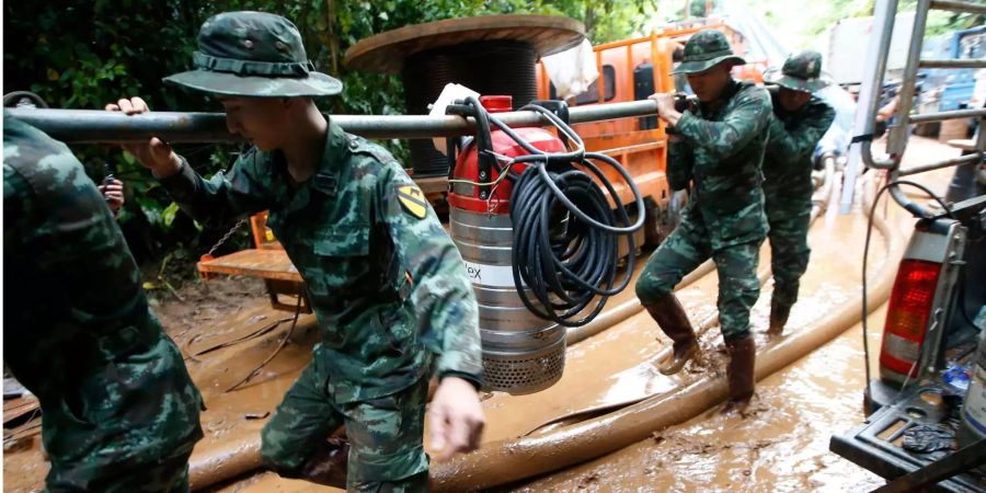 Soldaten tragen eine Wasser-Pumpe, um eine Höhle, in der seit mehreren Tagen eine Jugend-Fussballmannschaft eingeschlossen ist, zu entwässern.