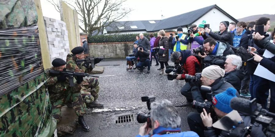 Journalisten fotografieren als Soldaten verkleidete Demonstranten.