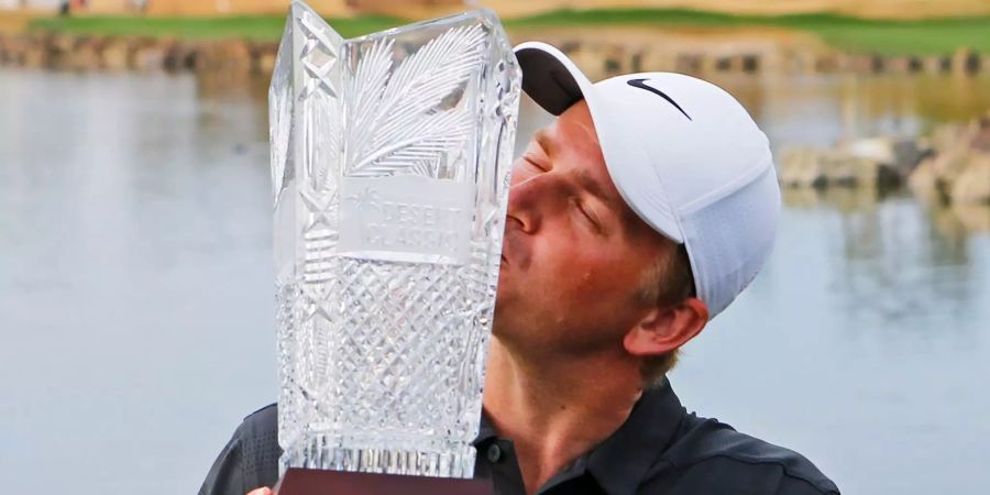 Adam Long küsst die Siegertrophäe.