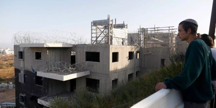 Israelische Siedler blicken auf ihre illegale Behausung.