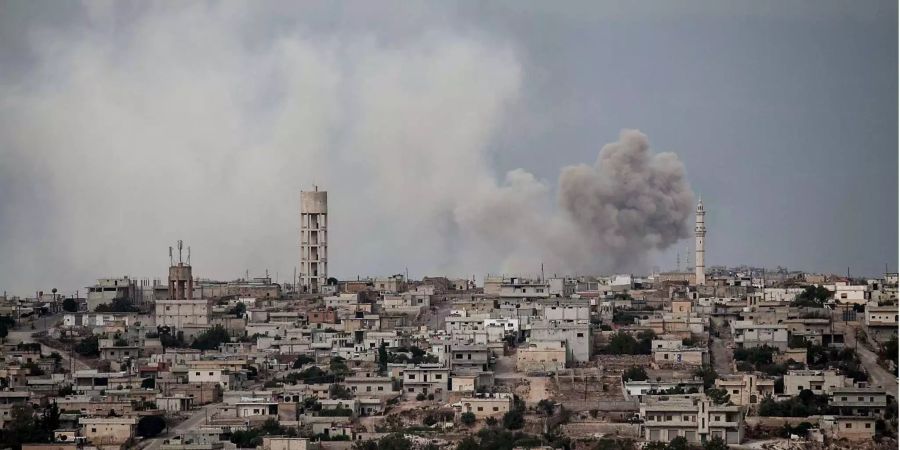 Rauch steigt aus einer Stadt in der Provinz Idlib auf.