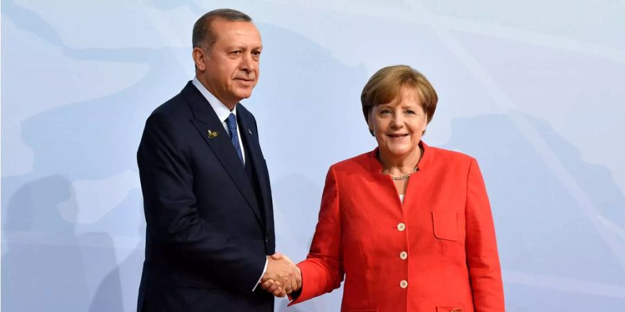 Die türkische Präsident Recep Tayyip Erdogan (l.) und die deutsche Bundeskanzlerin Angela Merkel (r.) begrüssen sich zu Beginn des G20-Gipfels 2017 in Hamburg.